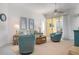 Living area with teal armchairs, a sofa, and coastal-themed art at 523 Fallbrook Dr, Venice, FL 34292