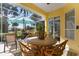 Relaxing screened patio with seating area, umbrella, and view of lush landscaping at 523 Fallbrook Dr, Venice, FL 34292