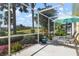 Peaceful screened patio with lounge chairs and umbrella; offering a relaxing outdoor space at 523 Fallbrook Dr, Venice, FL 34292