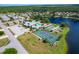 Community overview featuring tennis courts, pool, and clubhouse near a lake at 545 Foxwood Blvd # 23, Englewood, FL 34223