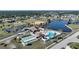 Scenic aerial shot of the community clubhouse with pool, tennis and shuffleboard near a picturesque lake at 6543 Coliseum Blvd, Port Charlotte, FL 33981