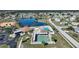 Aerial shot of community pool, shuffleboard, tennis, and lake, offering resort-style living at 6543 Coliseum Blvd, Port Charlotte, FL 33981