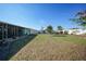 Beautifully manicured lawn with a view of the home's enclosed patio and white vinyl fence at 6543 Coliseum Blvd, Port Charlotte, FL 33981