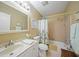 Neutral toned bathroom featuring a shower and tub combo, framed mirror, and white vanity at 6543 Coliseum Blvd, Port Charlotte, FL 33981