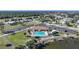 Aerial view of community pool with ample parking, clubhouse, and lush green surroundings at 6543 Coliseum Blvd, Port Charlotte, FL 33981