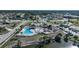 Aerial view of community pool with covered area, lush surroundings, and ample parking at 6543 Coliseum Blvd, Port Charlotte, FL 33981