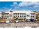 Condo exterior showing multiple units, landscaping, and ample parking at 6800 Placida Rd # 122, Englewood, FL 34224