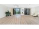 Spacious living room with sliding glass doors to a balcony, a ceiling fan, and light wood flooring at 6800 Placida Rd # 122, Englewood, FL 34224