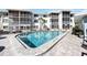 Community pool with brick pavers and lounge chairs at 708 Tamiami S Trl # 103, Venice, FL 34285