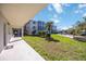 Walkway leading to a green space and building exterior at 708 Tamiami S Trl # 103, Venice, FL 34285