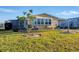 Yellow mobile home with carport and landscaping at 717 Tangerine Woods Blvd, Englewood, FL 34223