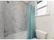 Bathroom with marble shower/tub combo and a teal shower curtain at 7186 Rosemont Dr, Englewood, FL 34224