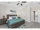 Main bedroom with ensuite bath access and teal bedding at 7186 Rosemont Dr, Englewood, FL 34224