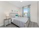 Bedroom with gray bedding, nightstands, and beach-themed decor at 7186 Rosemont Dr, Englewood, FL 34224