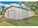 White detached garage with a single door and window at 7329 Mamouth St, Englewood, FL 34224