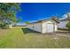 Detached garage with a white exterior and a grassy yard at 7329 Mamouth St, Englewood, FL 34224