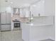 Modern kitchen with white cabinets, quartz counters, and stainless steel appliances at 7329 Mamouth St, Englewood, FL 34224