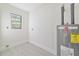 Laundry room with new water heater and gray tile floor at 7329 Mamouth St, Englewood, FL 34224