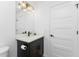 Modern bathroom with dark vanity, quartz countertop, and updated lighting at 7442 Clearwater St, Englewood, FL 34224