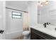 Simple bathroom with tub, toilet, and dark vanity at 7442 Clearwater St, Englewood, FL 34224