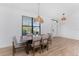 Dining room with wood table, light gray chairs, and modern pendant lights at 7442 Clearwater St, Englewood, FL 34224