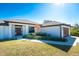 Front view of a single-story home with a brown door and landscaping at 7442 Clearwater St, Englewood, FL 34224