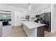 Modern kitchen featuring white cabinets, stainless steel appliances, and a large island at 7442 Clearwater St, Englewood, FL 34224