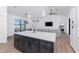 Kitchen island with seating, quartz countertop, and dark gray cabinets at 7442 Clearwater St, Englewood, FL 34224