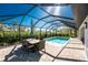 Screened pool and patio with outdoor dining set and ample seating at 7442 Clearwater St, Englewood, FL 34224