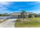 Cute Florida home with a palm tree, white fence, and spacious driveway at 7586 Sea Mist Dr, Port Charlotte, FL 33981