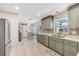 Modern kitchen with light green cabinets and stainless steel appliances at 7586 Sea Mist Dr, Port Charlotte, FL 33981