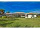 House back view with a large screened lanai at 8 Sportsman Rd, Rotonda West, FL 33947