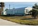 Mobile home with teal exterior, landscaping, and paved road at 8194 Robert St, Englewood, FL 34224