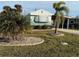 Mobile home with teal exterior, landscaping, and a paved driveway at 8194 Robert St, Englewood, FL 34224