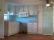 Simple kitchen with white cabinets and microwave at 8194 Robert St, Englewood, FL 34224