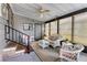 Relaxing screened porch with wicker furniture and ceiling fan at 844 Seabrooke Ct, Englewood, FL 34223