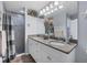 This bathroom features granite counters, white cabinets, and a glass-enclosed tiled shower at 9240 New Martinsville Ave, Englewood, FL 34224