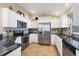 Modern kitchen with stainless steel appliances, granite countertops, and white cabinetry at 9240 New Martinsville Ave, Englewood, FL 34224