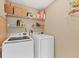 Functional laundry room featuring a washer, dryer, and shelving for storage at 9240 New Martinsville Ave, Englewood, FL 34224