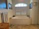 Oval soaking tub with marble surround and large window at 9458 Melody Circle, Port Charlotte, FL 33981