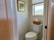 Small half bathroom with a toilet and wicker basket at 9458 Melody Circle, Port Charlotte, FL 33981