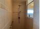 Walk-in shower with tiled walls and safety bar at 9458 Melody Circle, Port Charlotte, FL 33981