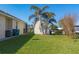 The backyard has green grass, a shed, and palm trees at 9676 Singer Cir, Port Charlotte, FL 33981