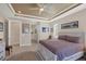 A primary bedroom featuring neutral tones, tray ceilings and an open doorway to a hallway at 9676 Singer Cir, Port Charlotte, FL 33981