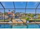 A close up shot of the pool and the water fountain feature with a lake view beyond at 9676 Singer Cir, Port Charlotte, FL 33981