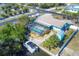 An aerial view showcasing a screened-in pool, canal access, RV parking, a shed, and lush tropical landscaping at 1005 E 2Nd St, Englewood, FL 34223