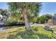 Landscaped backyard features canal access with a boat lift, an outdoor fire pit and mature palm trees at 1005 E 2Nd St, Englewood, FL 34223