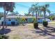 Charming single story home features mature landscaping with palm trees and a light blue exterior at 1005 E 2Nd St, Englewood, FL 34223