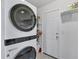 Well-organized laundry room with a modern stacked washer/dryer and shelving for extra storage at 1005 E 2Nd St, Englewood, FL 34223