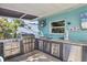 Outdoor kitchen area with stainless steel appliances, countertop space, and a small window at 1005 E 2Nd St, Englewood, FL 34223
